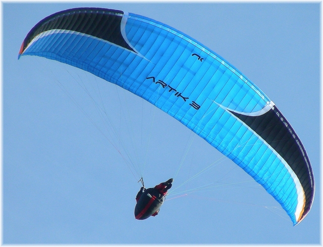  Gleitschirmfliegen über blauem Himmel 
